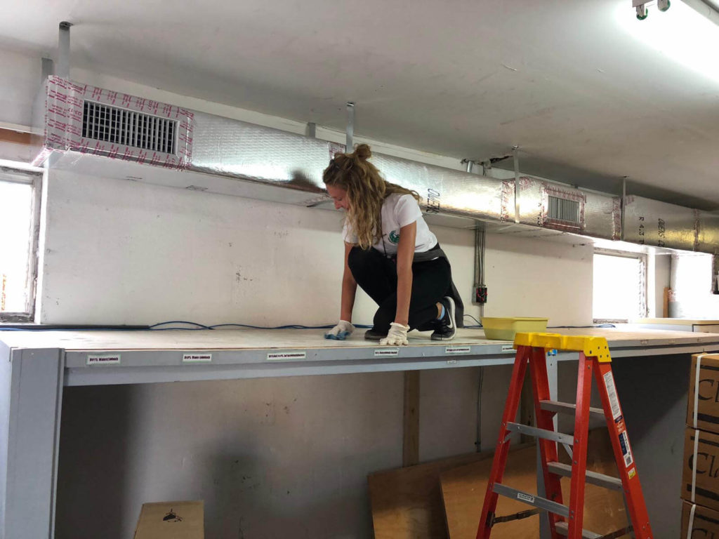 Kristin cleans and disinfects shelves at the Rand Memorial Hospital pharmacy warehouse.