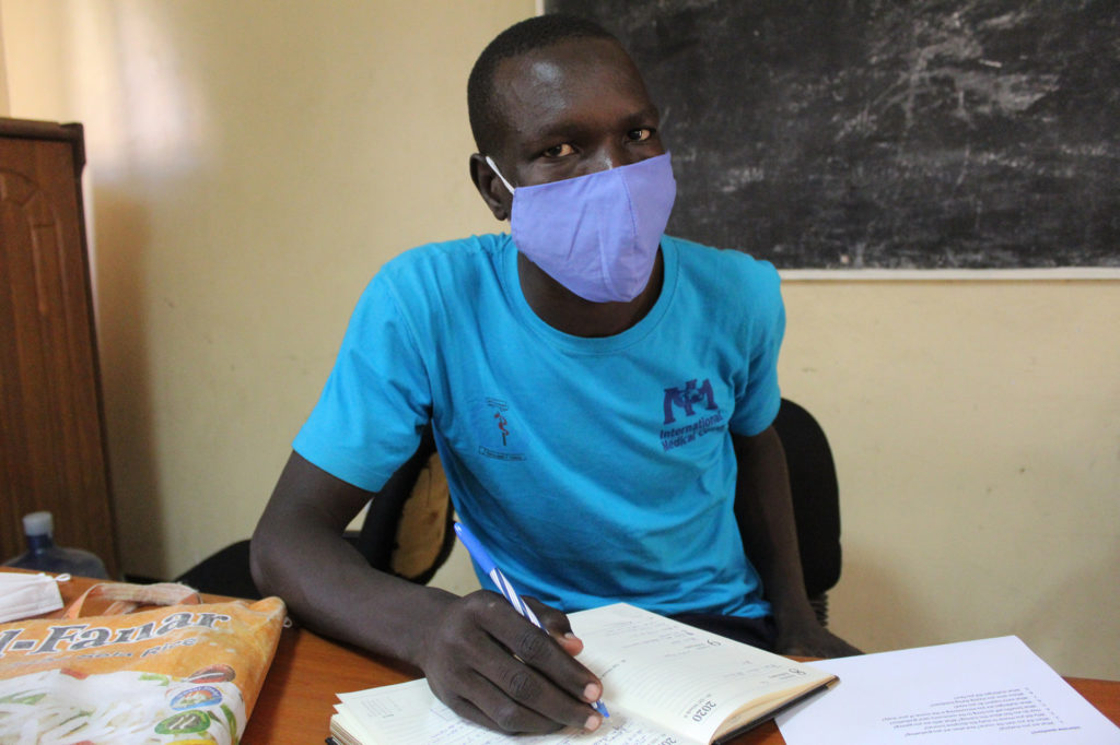 Samuel Kenyi reviews his notes in a lecture theater. He is a third-year midwifery at Kajo-Keji Health Science School.