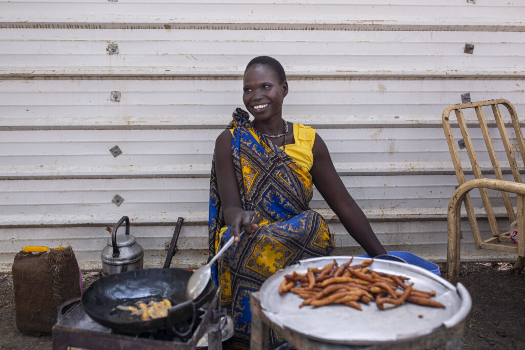 Nyabach John, 25, works at her food stand in Malakal, South Sudan, on March 19, 2021.