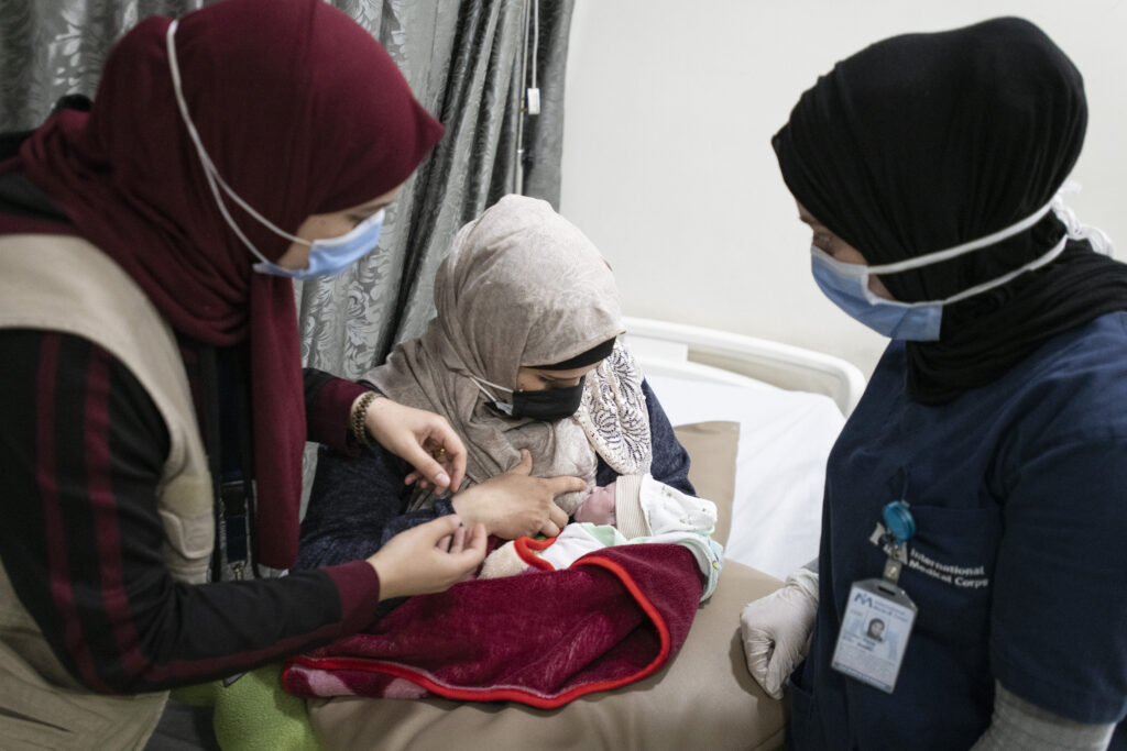 International Medical Corps specialized staff teaching mother (Isra'a Ismail Ahmad) how to breastfeed her baby, in the International Medical Corps Maternity ward, Irbid Specialty Hospital, Irbid, Jordan.