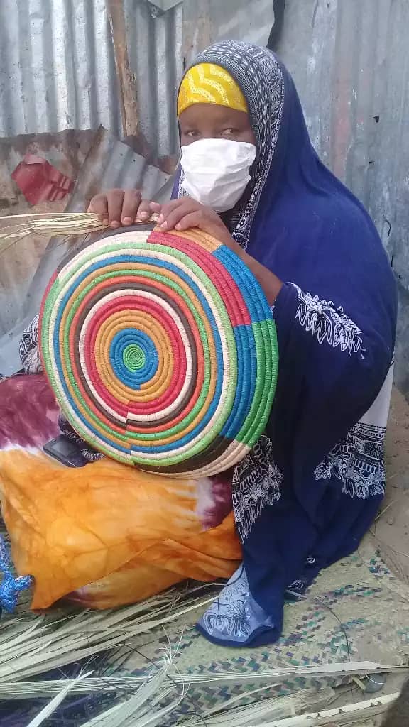 Maryan Abdi Mohammed weaves a colorful basket that she will sell in the local market. She makes baskets, mats and hats, and her business is profitable, bringing meaningful income to her family.