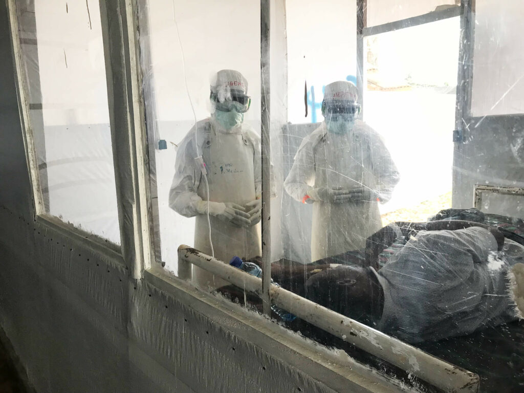 Staff check on a patient in the Mangina Ebola Treatment Center in North Kivu province, DRC.