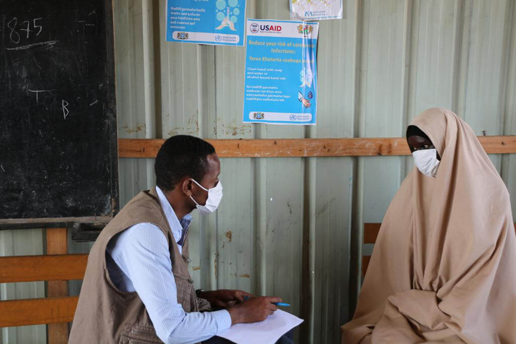 Hawo Aliyow (right) discusses the COVID-19 pandemic with an International Medical Corps staff member.