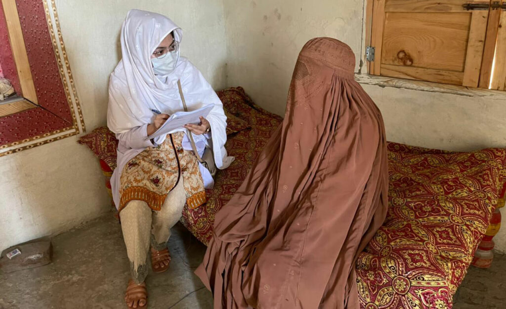 A data collector interviews a female community member.