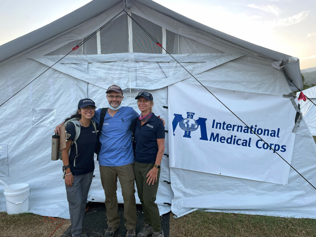 Outside the EMT, Sue Mangicaro (right) poses with Dr. Chad Knaus and volunteer Lila Olman.