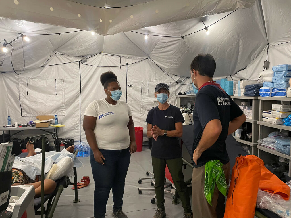 Sue Mangicaro (center) speaks with John Roberts (right) and Vanessa Delone Jean Louis inside the EMT.