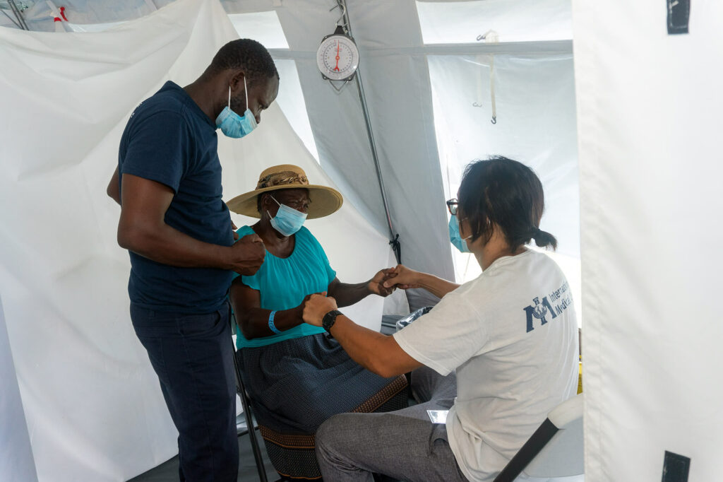 Volunteer doctor Alex Wang treats a Haitian woman with the help of a local translator, Yacinthe Venord.