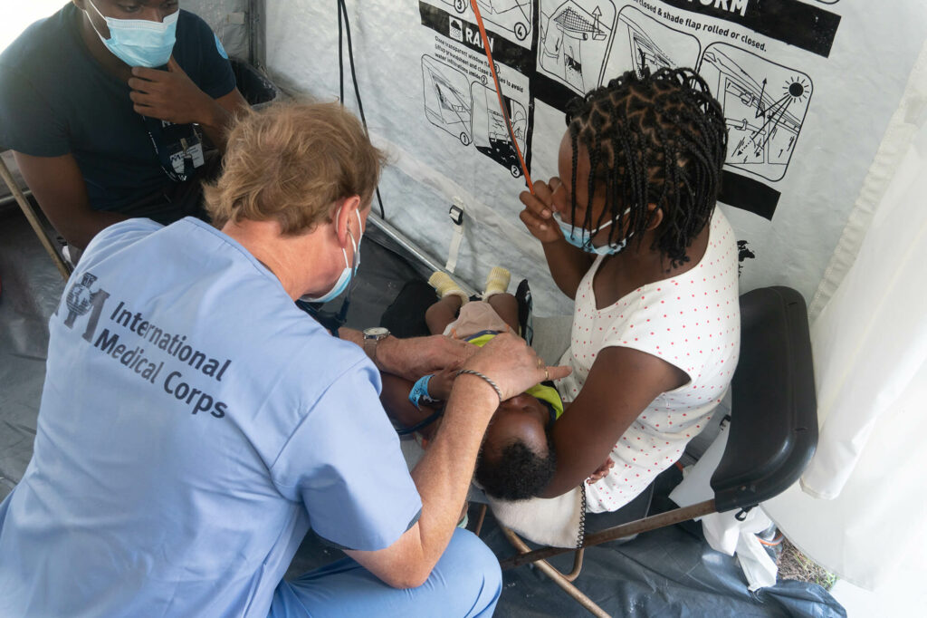 Volunteer doctor Thomas Bernadzikowski performs a checkup on a baby in the EMT.