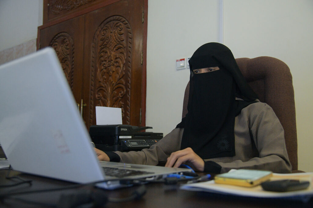 Eman at her desk in the International Medical Corps office in Ibb, Yemen.