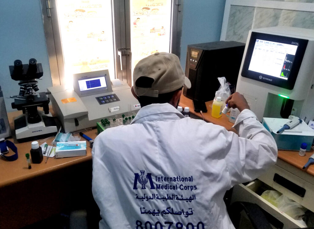 Community Health Volunteer Ali Fadhel works in the Khela health facility lab.