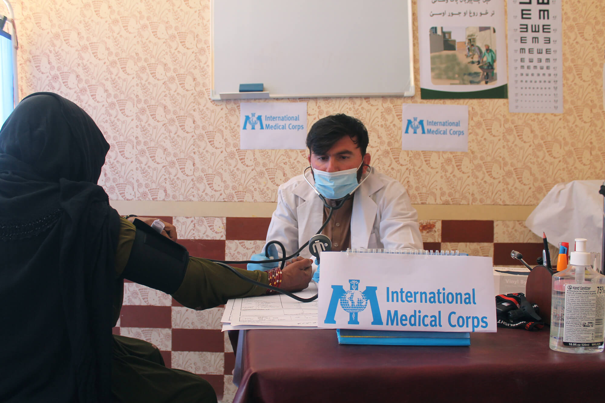 Dr. Hashmatullah Irfan provides healthcare services to an elderly woman at the health center in Dehsabz.