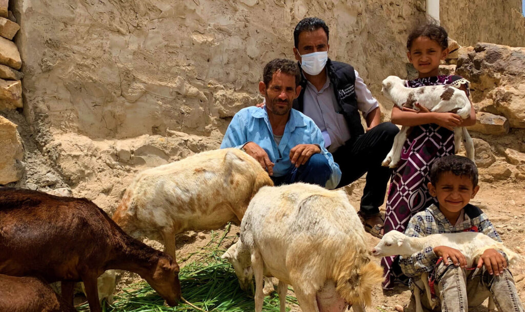 Abduljabbar Ahmed, left, is shown with his new herd of sheep and a member of International Medical Corps' Food Security and Livelihoods team, as well as his daughter Libnan and son Issa.