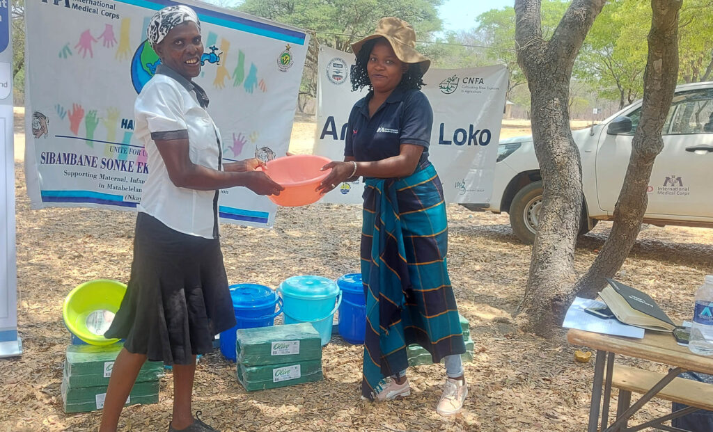 A participant receives a prize for winning a handwashing quiz competition in Nkayi District.