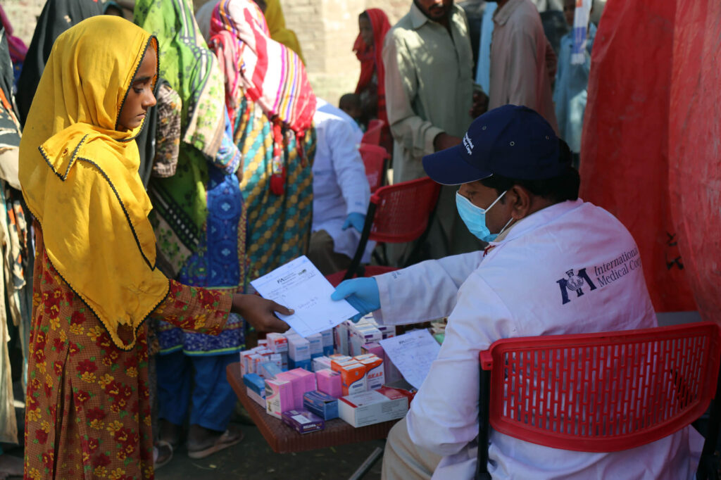 Pathani’s daughter hands the prescription for Sajjad’s treatment to an International Medical Corps pharmacist, Ubed Ullah.