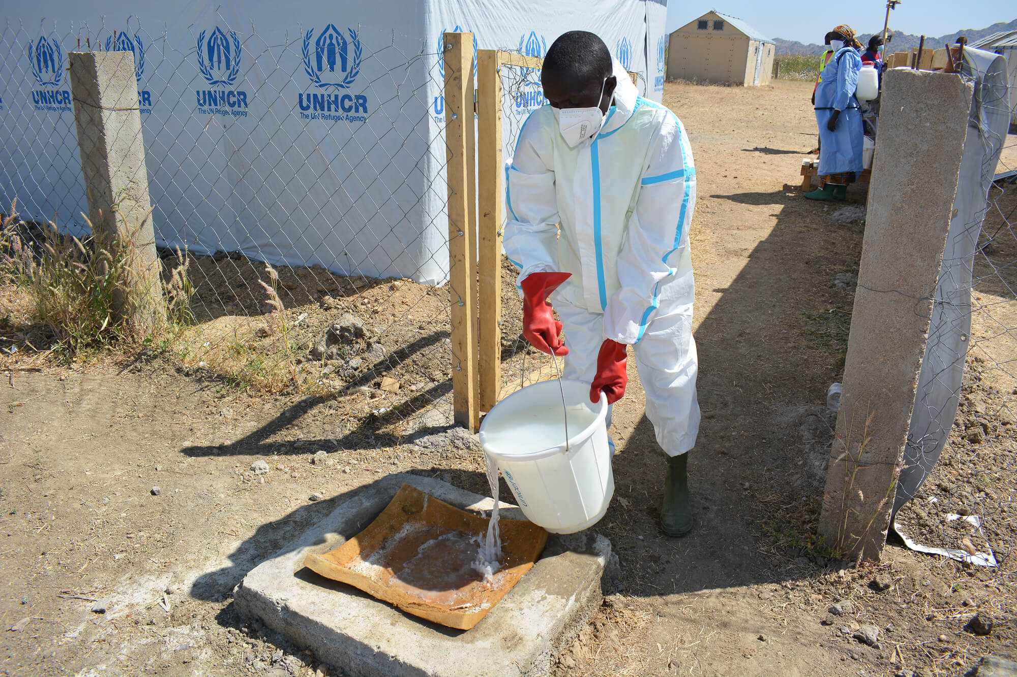 Modu Modu, a community health worker, disinfects a mat in the cholera treatment centre with a diluted chlorine solution.