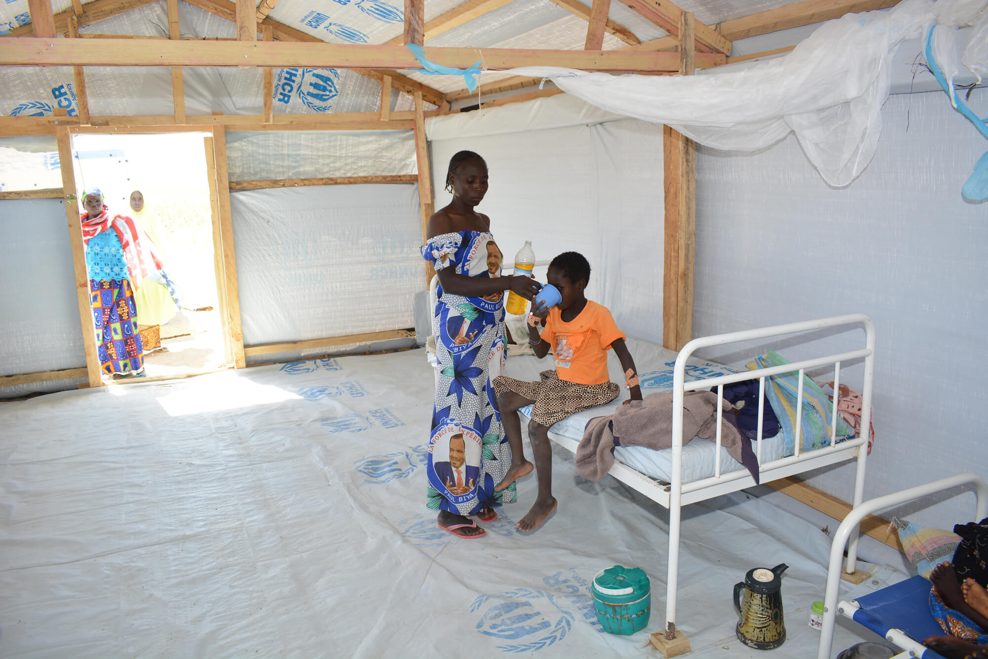 A cholera patient’s mother provides oral rehydration solution to her child in the cholera treatment centre.