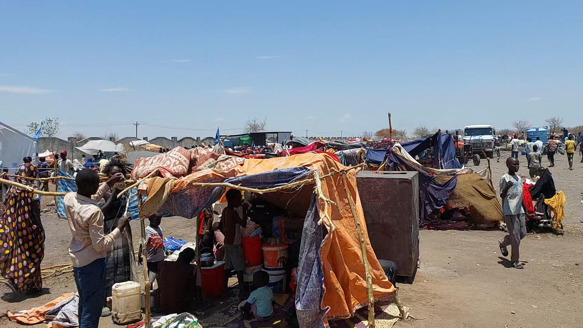 Sudanese refugees and returnees wait in makeshift shelters at a transit camp in Renk, South Sudan.