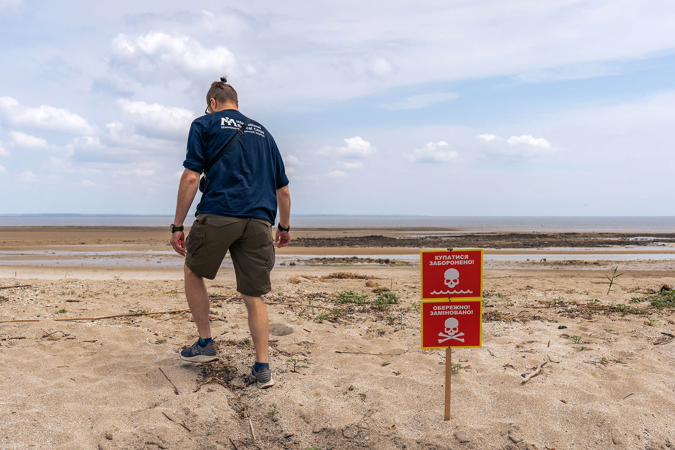 International Medical Corps WASH Assistant Zakhar Ziabkyn assesses decreased water levels in the Kakhovka Reservoir near Novovoronsovka, a village located in Khersonska oblast.