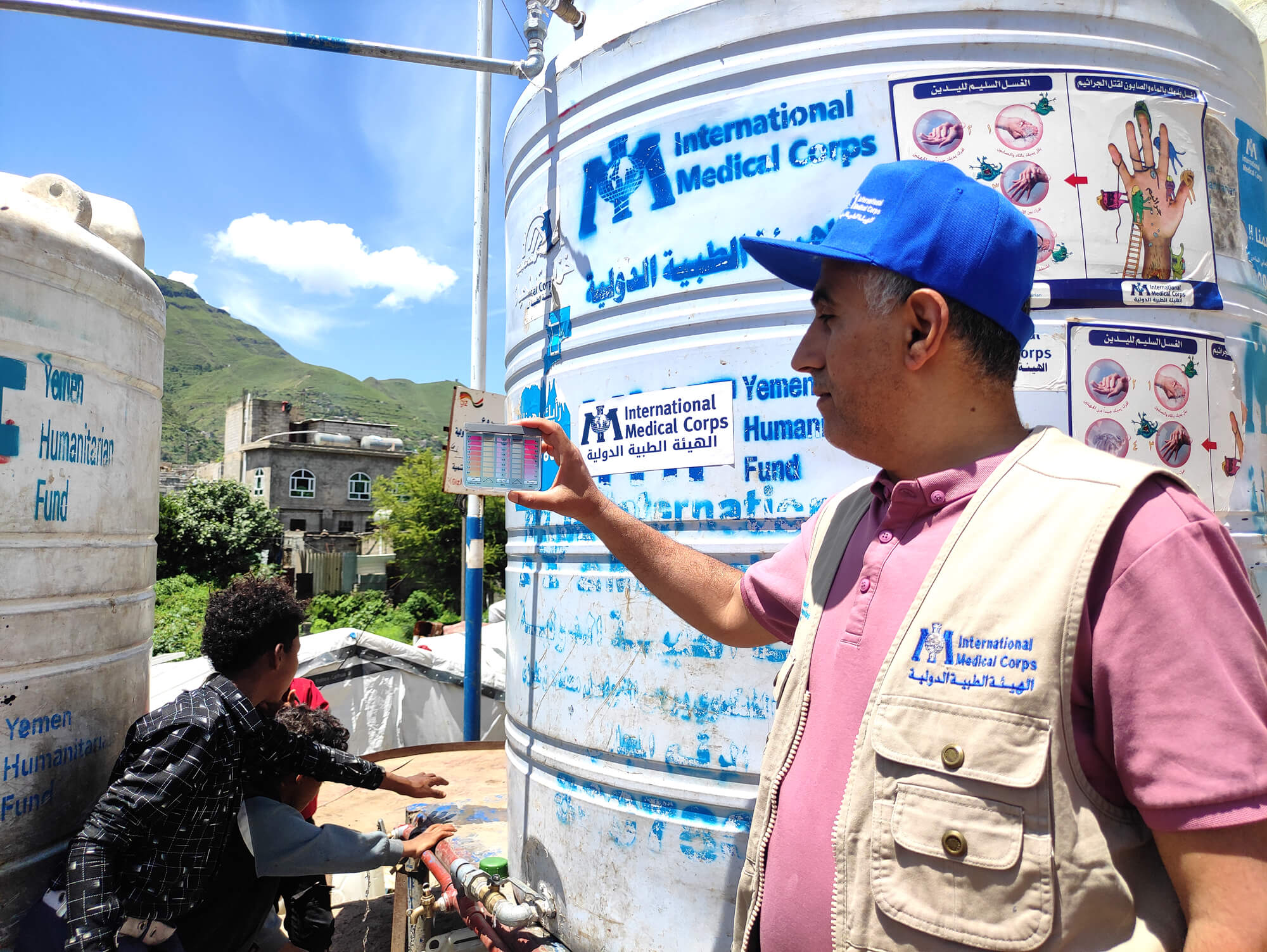 Esmail measures the chlorine level of a water point in an IDP camp to make sure the water is safe to drink.