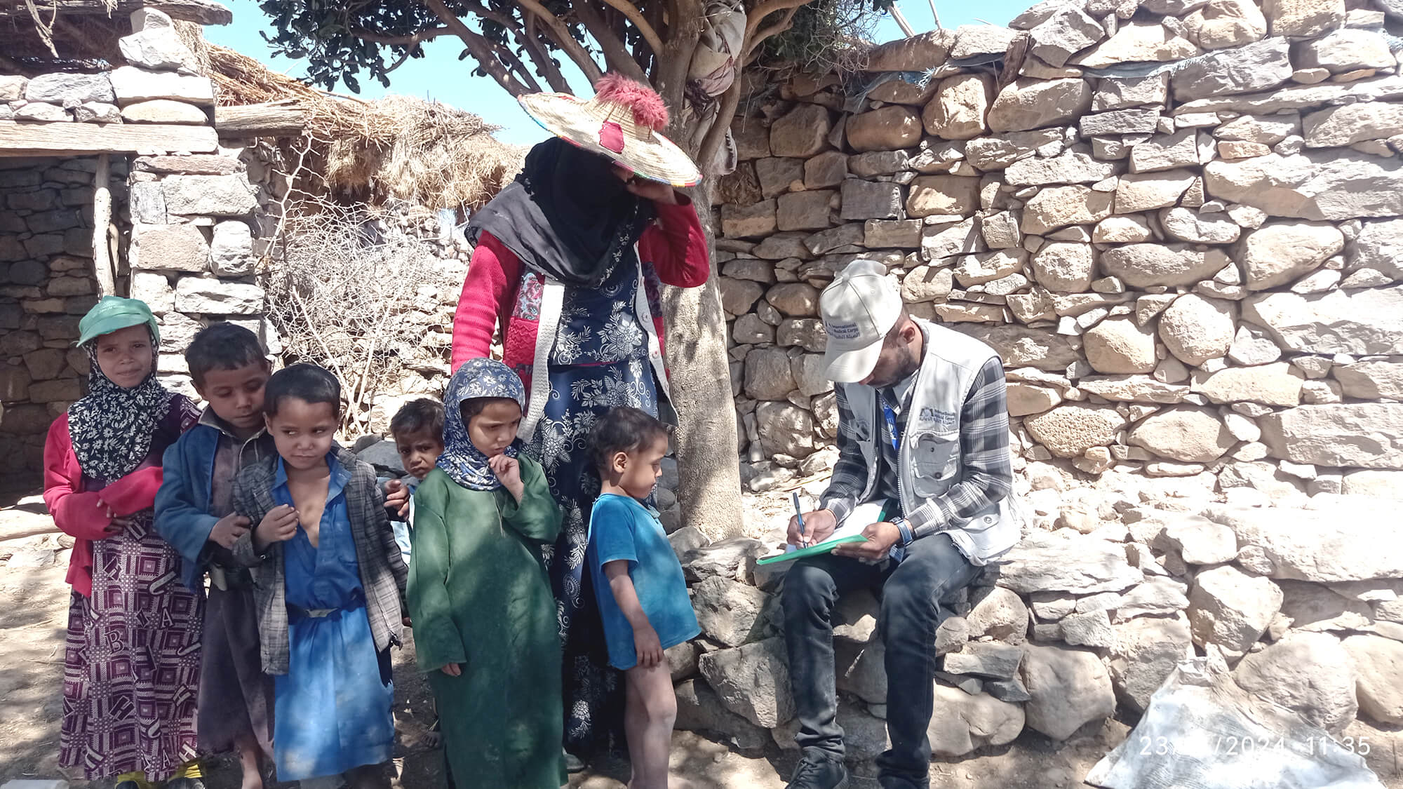 Hosn Saeed Abdullah Ahmed Al-Majnahi stands with her six children in Al-Dhahra village, Yemen.