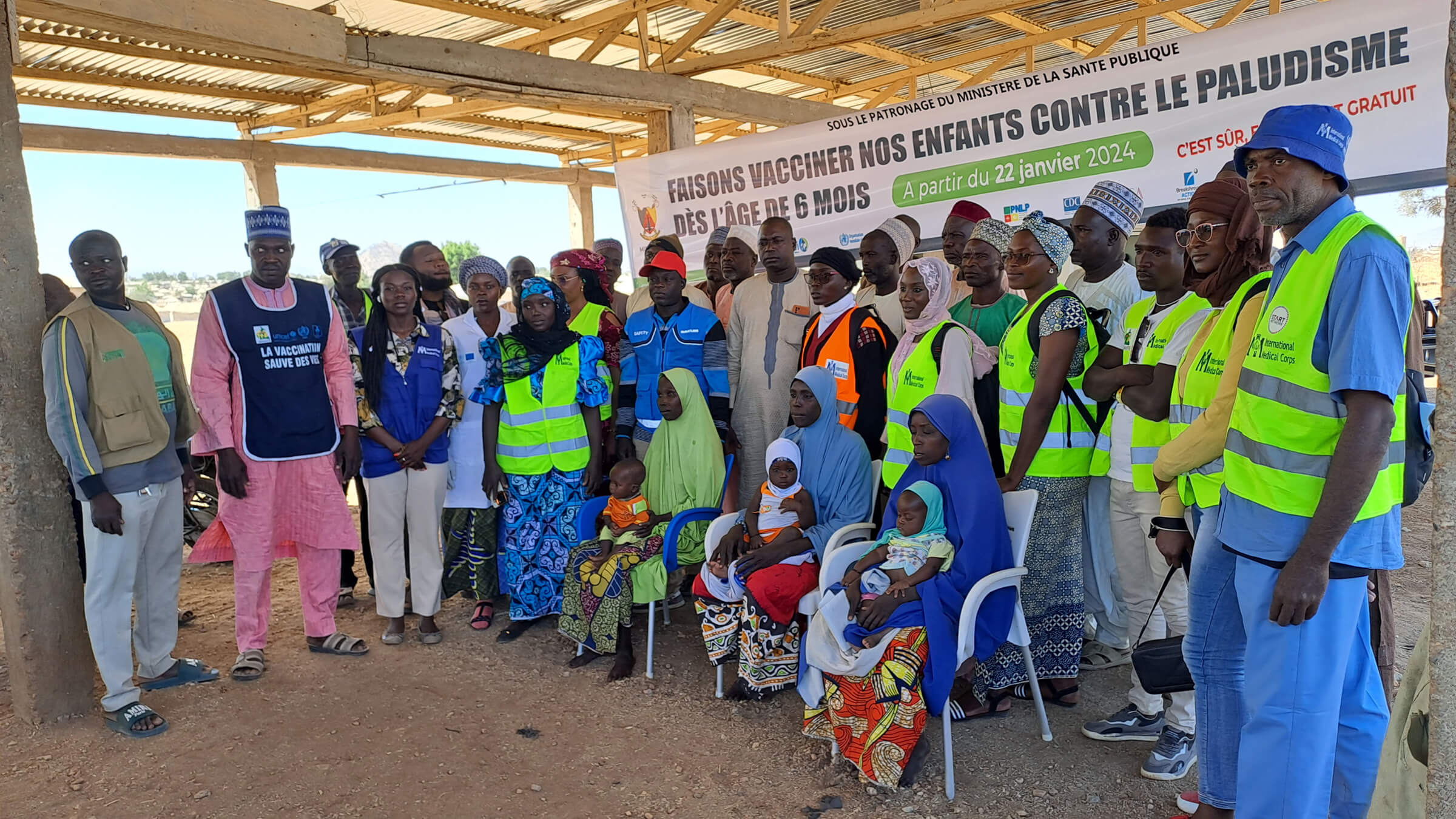 Community health workers, healthcare staff and mothers pose with some of the first children vaccinated in Cameroon’s anti-malaria vaccination campaign.