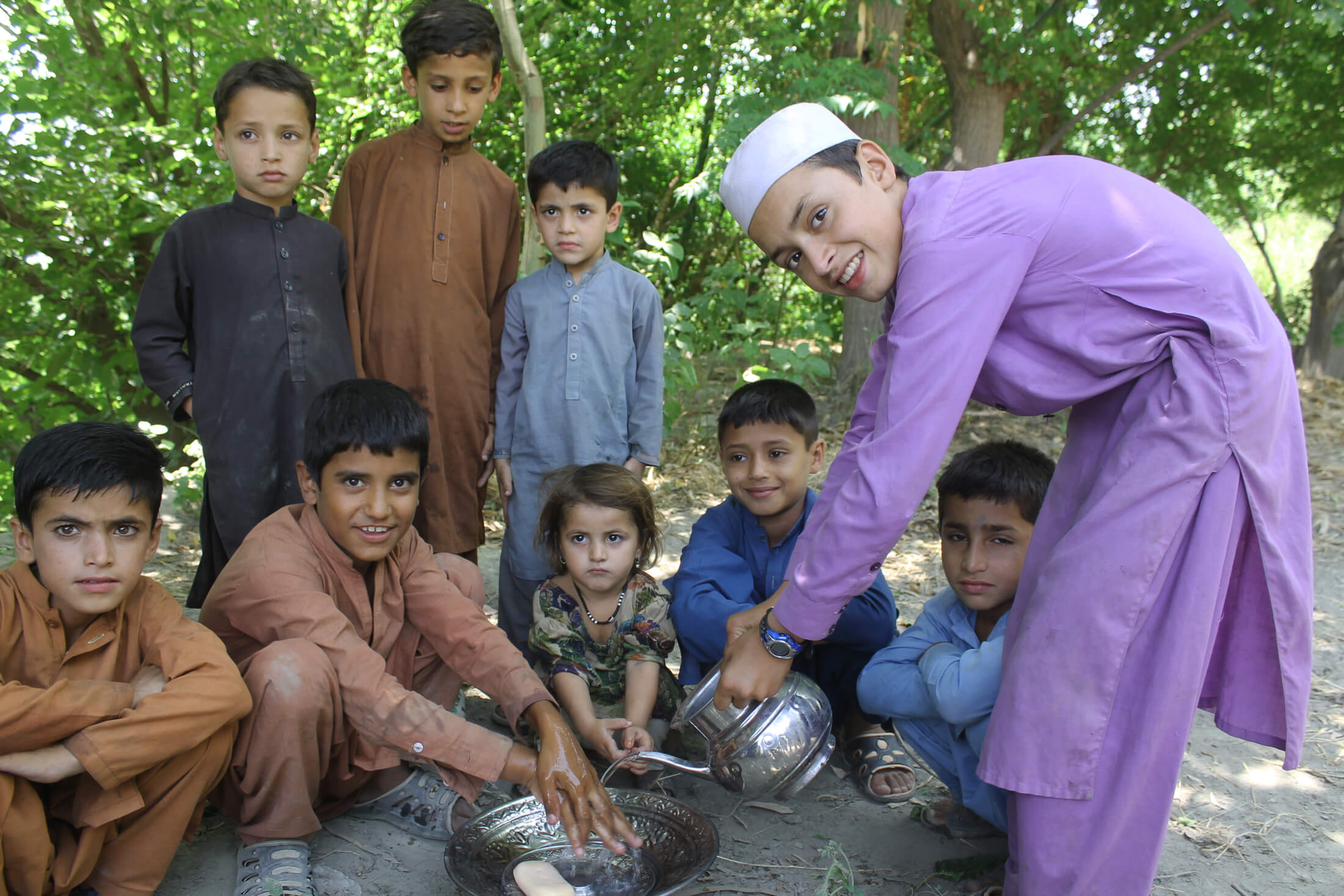 After learning about the importance of handwashing to prevent waterborne diseases like cholera, children in Afghanistan practice washing their hands.