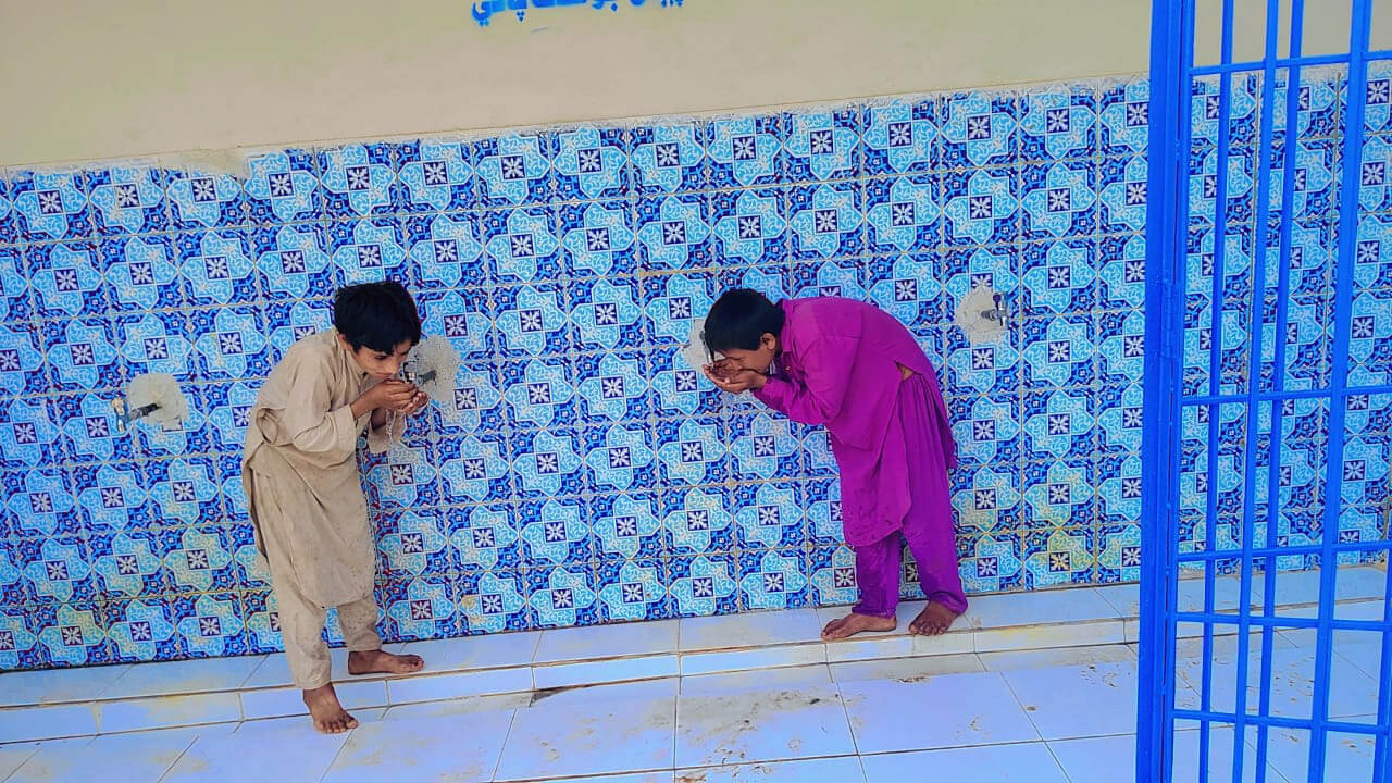 Children drink from the taps at the rehabilitated reverse-osmosis water purification plant in a village in Pakistan.