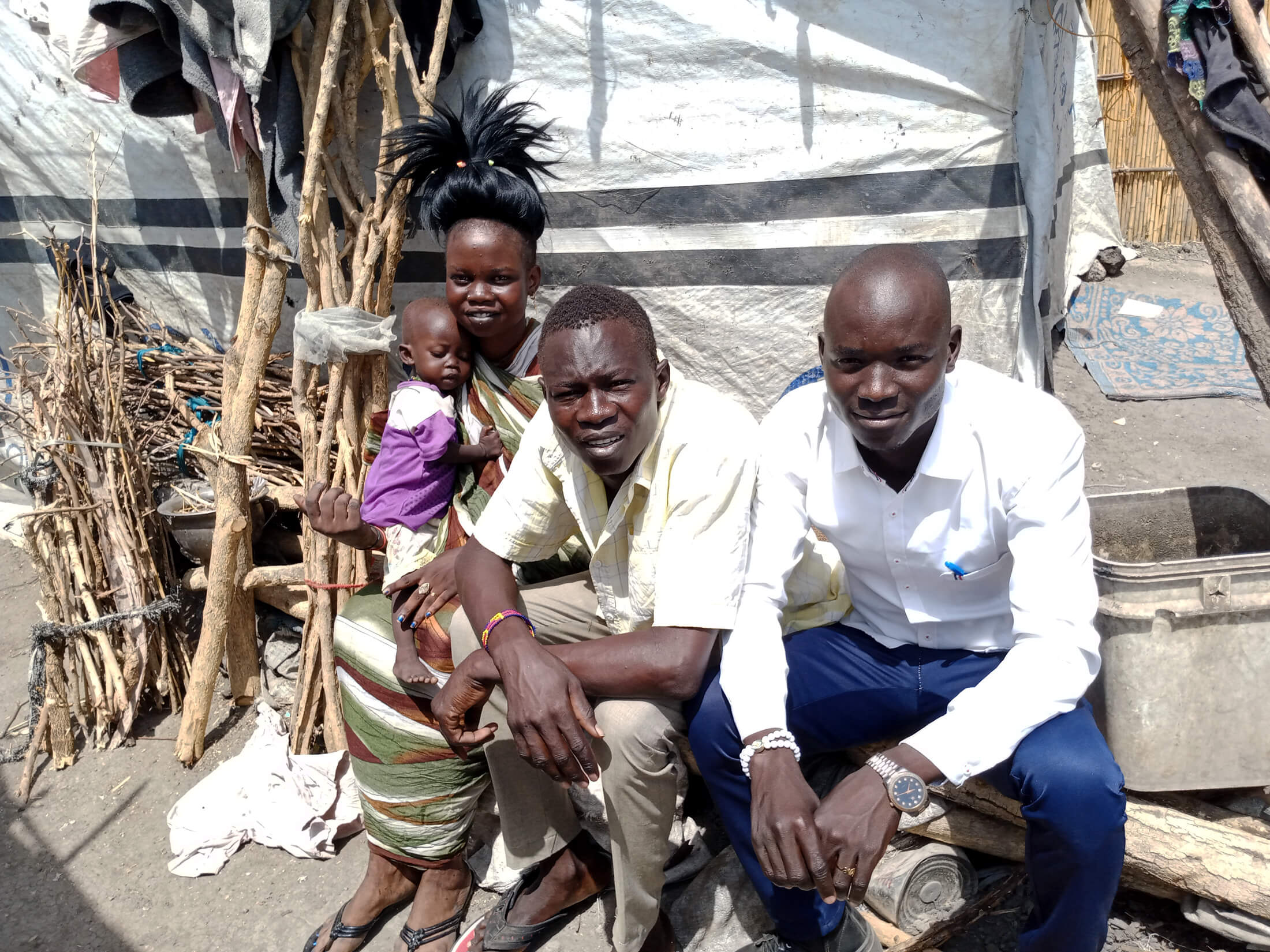 Phillip Daniel Awuo (center) sits with his wife, child and Duku Evans Chaplain, an International Medical Corps MHPSS Officer who works in Malakal.