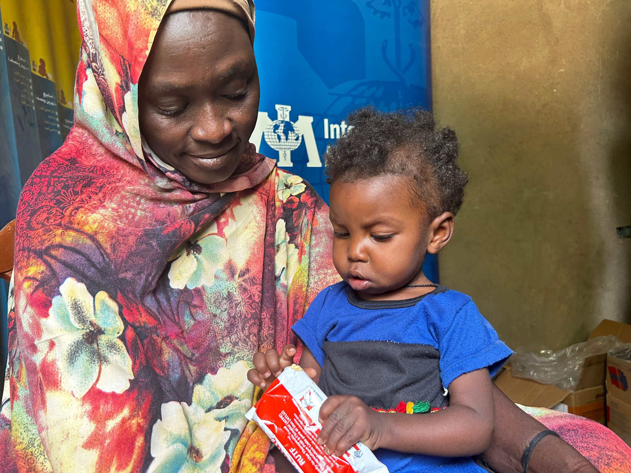 2-year-old Zainab holds ready-to-use therapeutic food—a high-energy paste that helps treat malnutrition in young children.