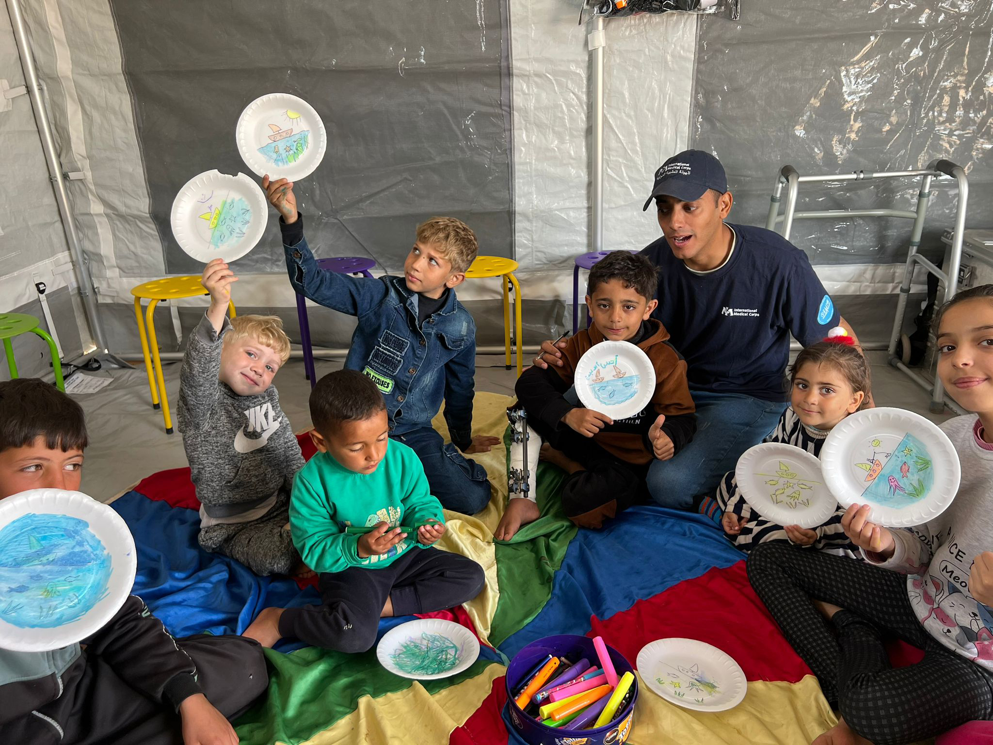 International Medical Corps runs MHPSS activities for adults and children at the field hospitals, such as this arts and crafts session in the child-friendly tent.