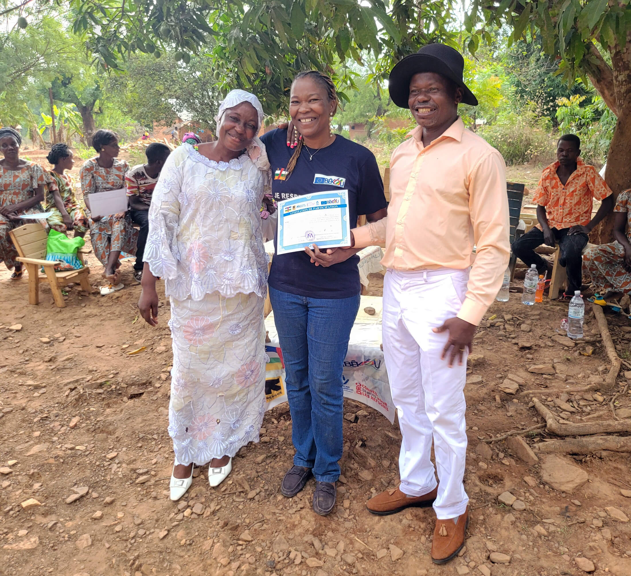 Bedi Bienvenue, center, presents a certificate to two community leaders.