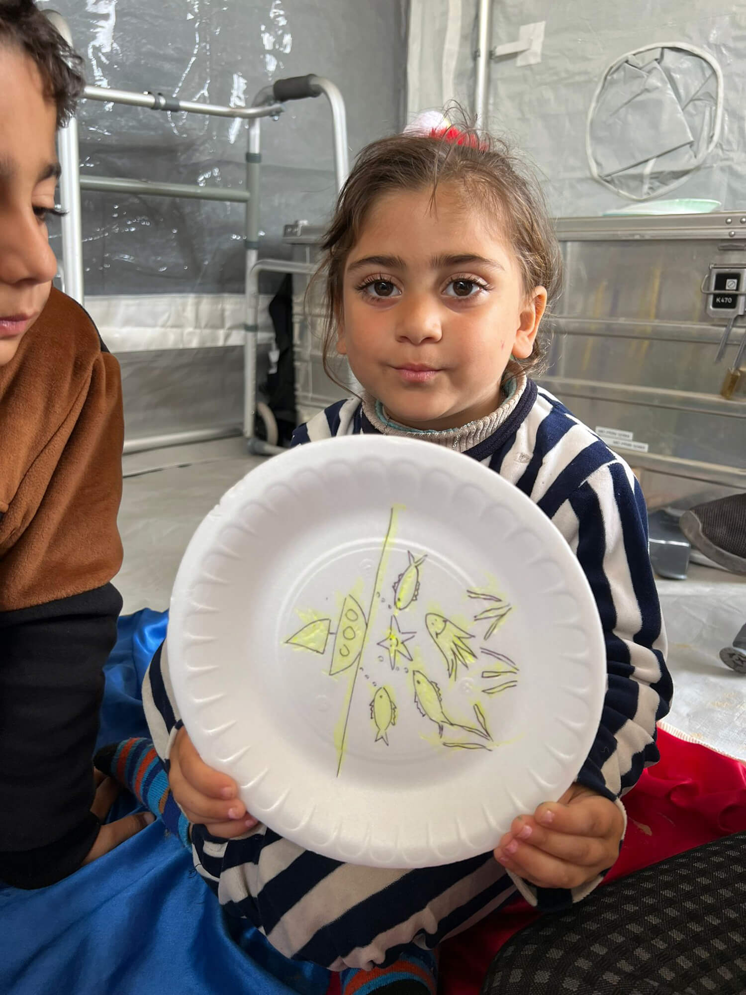 4-year-old Nahla shows some of the artwork she made in our child-friendly tent.