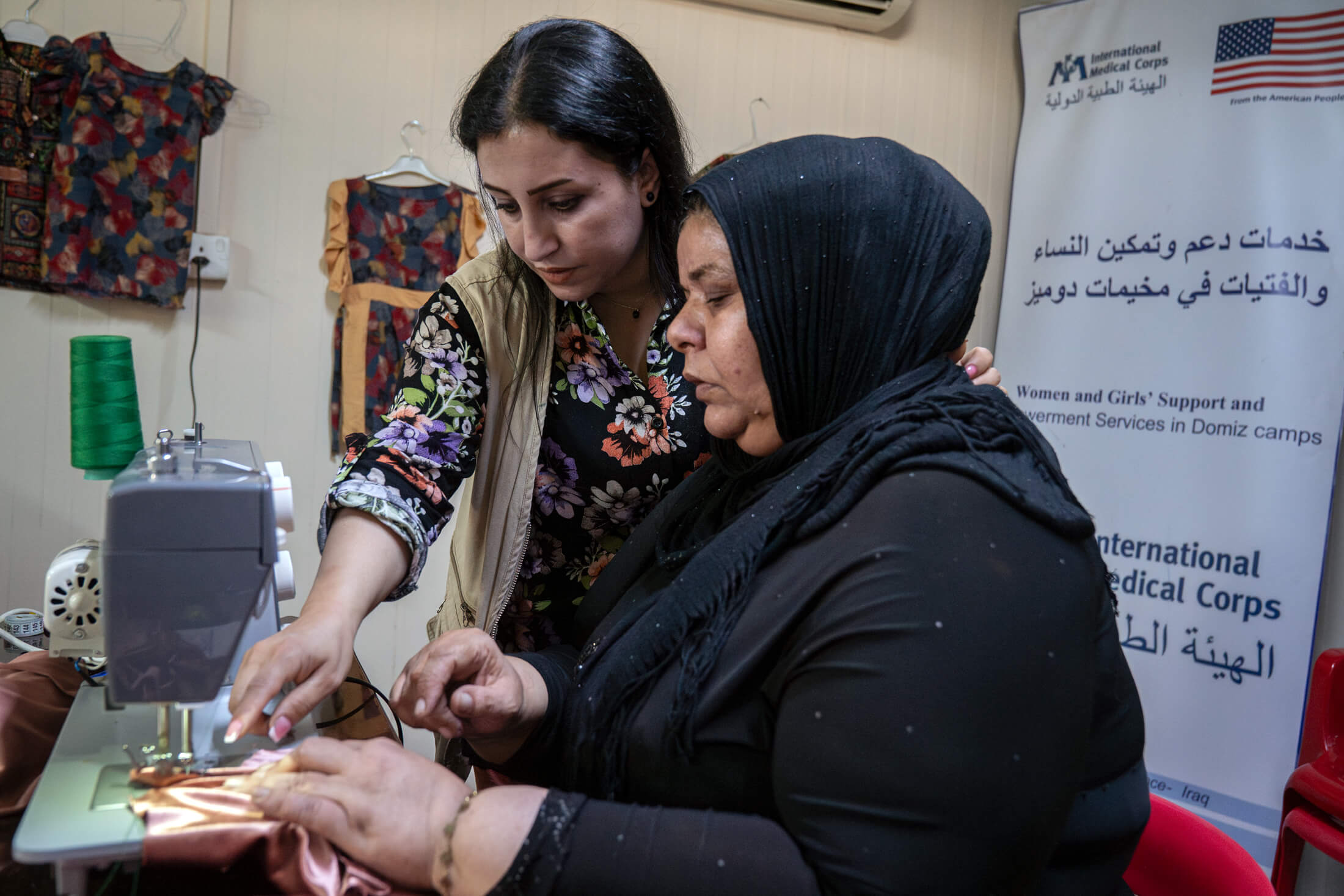 Lava (left) helps Fidha (right) with her project. Fidha and her husband escaped bombings in Damascus in 2012 and have lived in the refugee camp ever since.