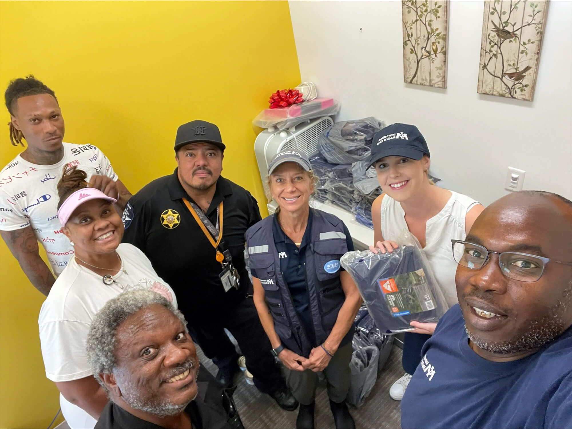 International Medical Corps staff pose for a selfie with staff members from the Legacy Fifth Ward Clinic, including Clinical Operations Manager Felicia Cruise (in the pink visor), staff members Carlos Sanchez (black hat) and Kevin Debose (bottom left) and Felicia’s son, Jabaris Cruise (upper left). Like most in the region, Felicia and her son were still without power at the time of this photo—yet they still helped us deliver supplies late on a Friday, carrying health supplies up several flights of stairs.