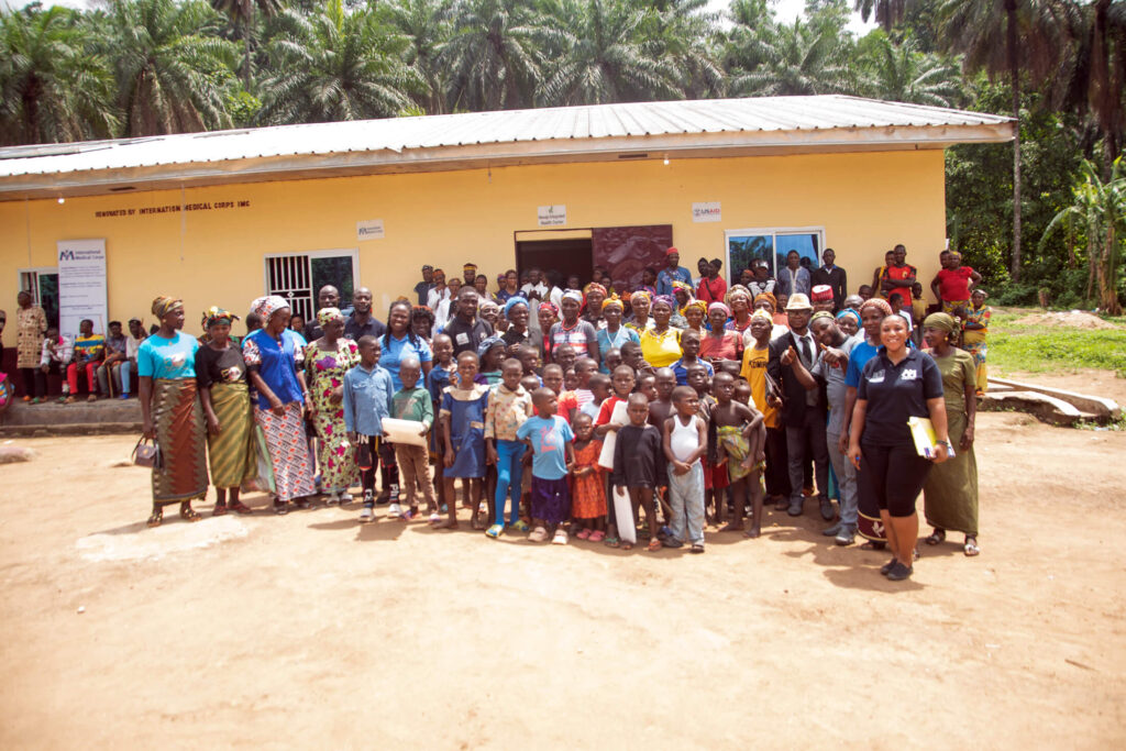 Villagers from Akwaja gather to celebrate the installation of solar panels on the roof of their local health center.