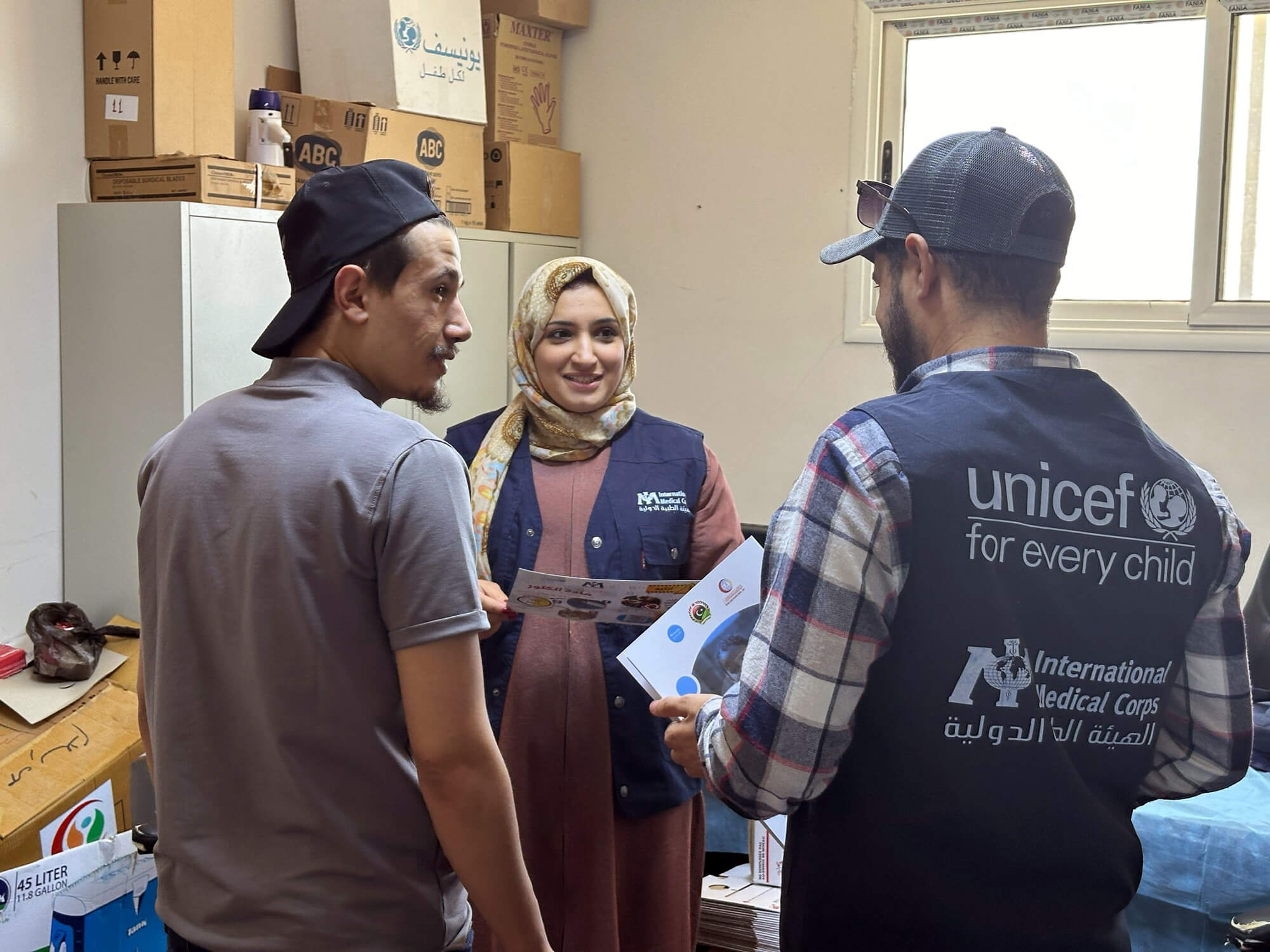 Dr. Rowayda (center) speaks with her WASH colleagues, including Tayseer El-Haj (right).