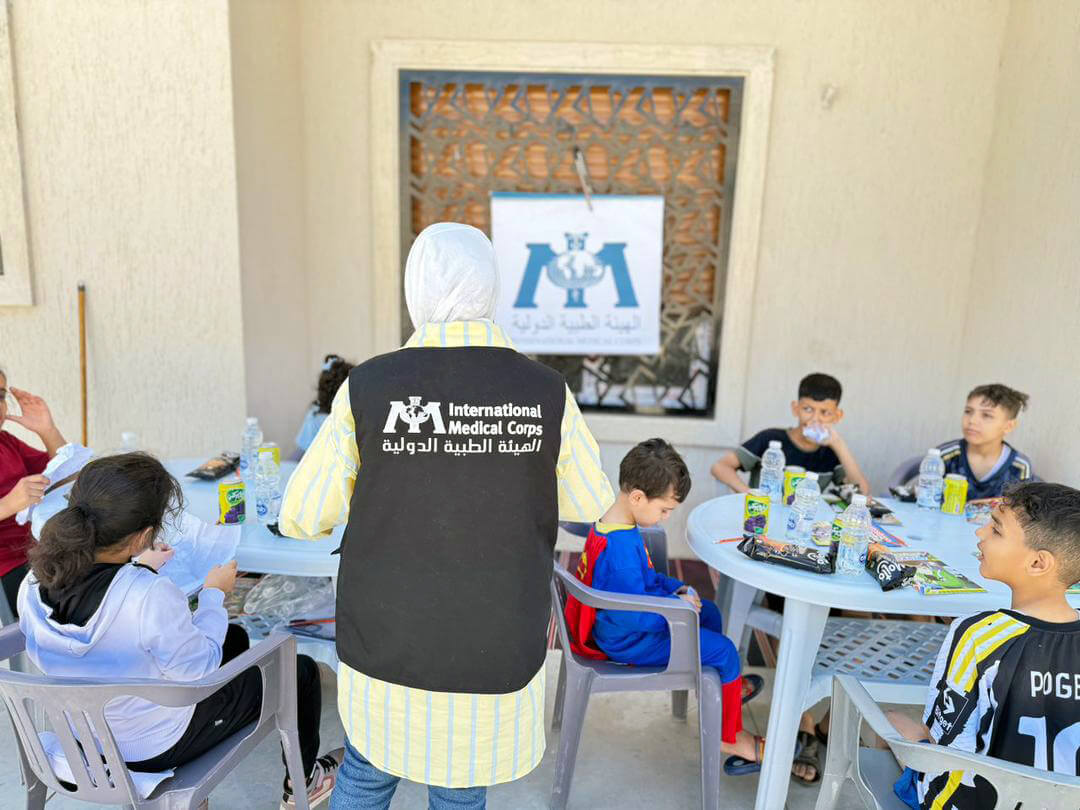 MHPSS Counselor Fatima Sanallah leads a recreational activity with children at an apartment building in Misrata, where many people who were displaced from Derna now live.