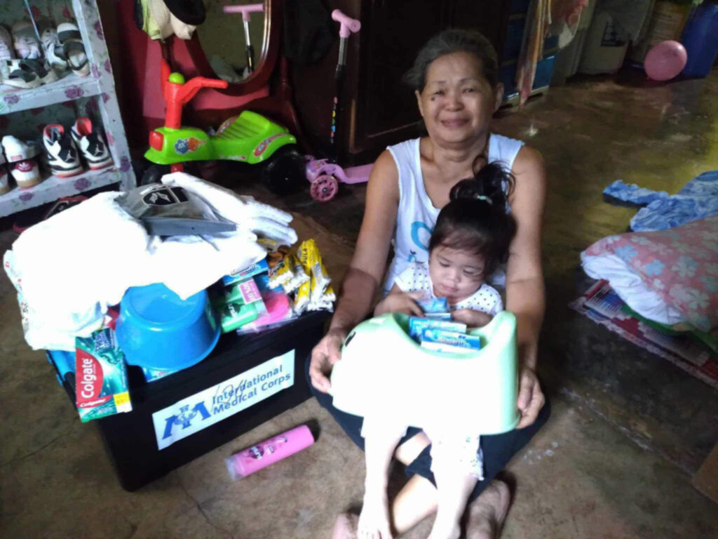 Imelda Chinel and her two-year-old granddaughter, Makayla Louise Chinel, receive a hygiene kit from International Medical Corps. Because of damage to their home from Typhoon Gaemi, they are now living with relatives.