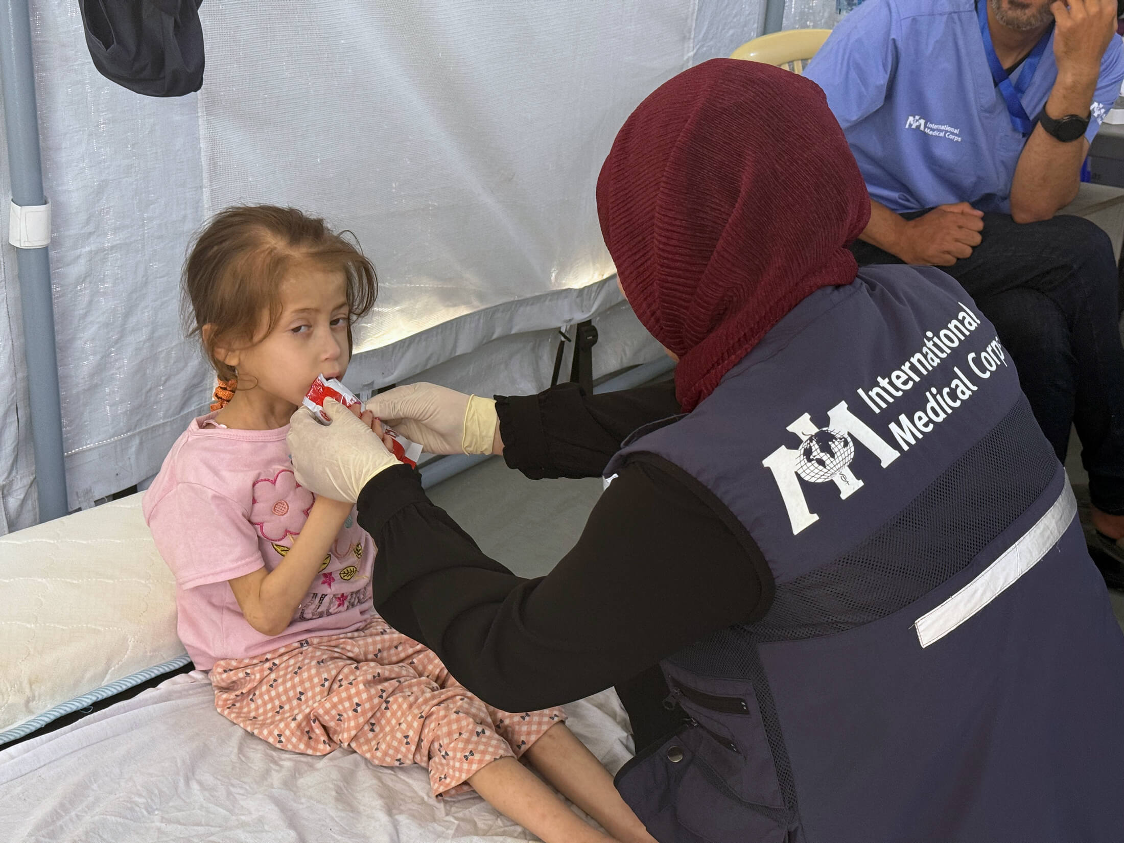 Dr. Mariam feeds Jana a packet of ready-to-use therapeutic food to help her get much-needed calories and nutrients.