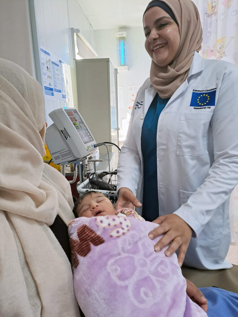 Midwife Riham checks in on Kafiah and baby Hala after the delivery.