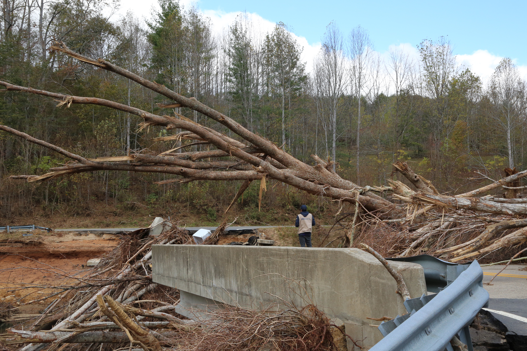 Adrian Rivera examines the destruction that forced our team to find a new route when attempting to deliver a 1,000-gallon water tank to a health partner in the Asheville area.