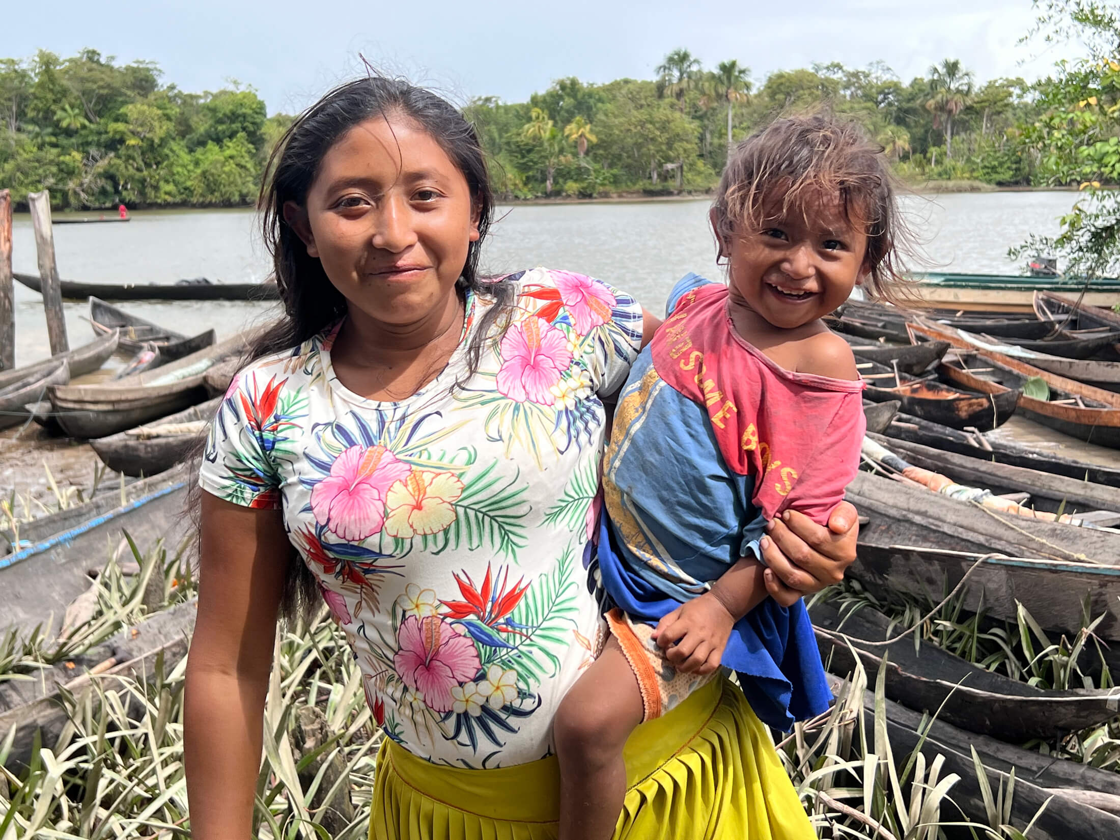 A mother and daughter from the Warao indigenous community smile for the camera while picking up their food package as part of the WFP school meals programme in Bella Vista in Delta Amacuro. (Photo: Lorena Garcia, WFP)