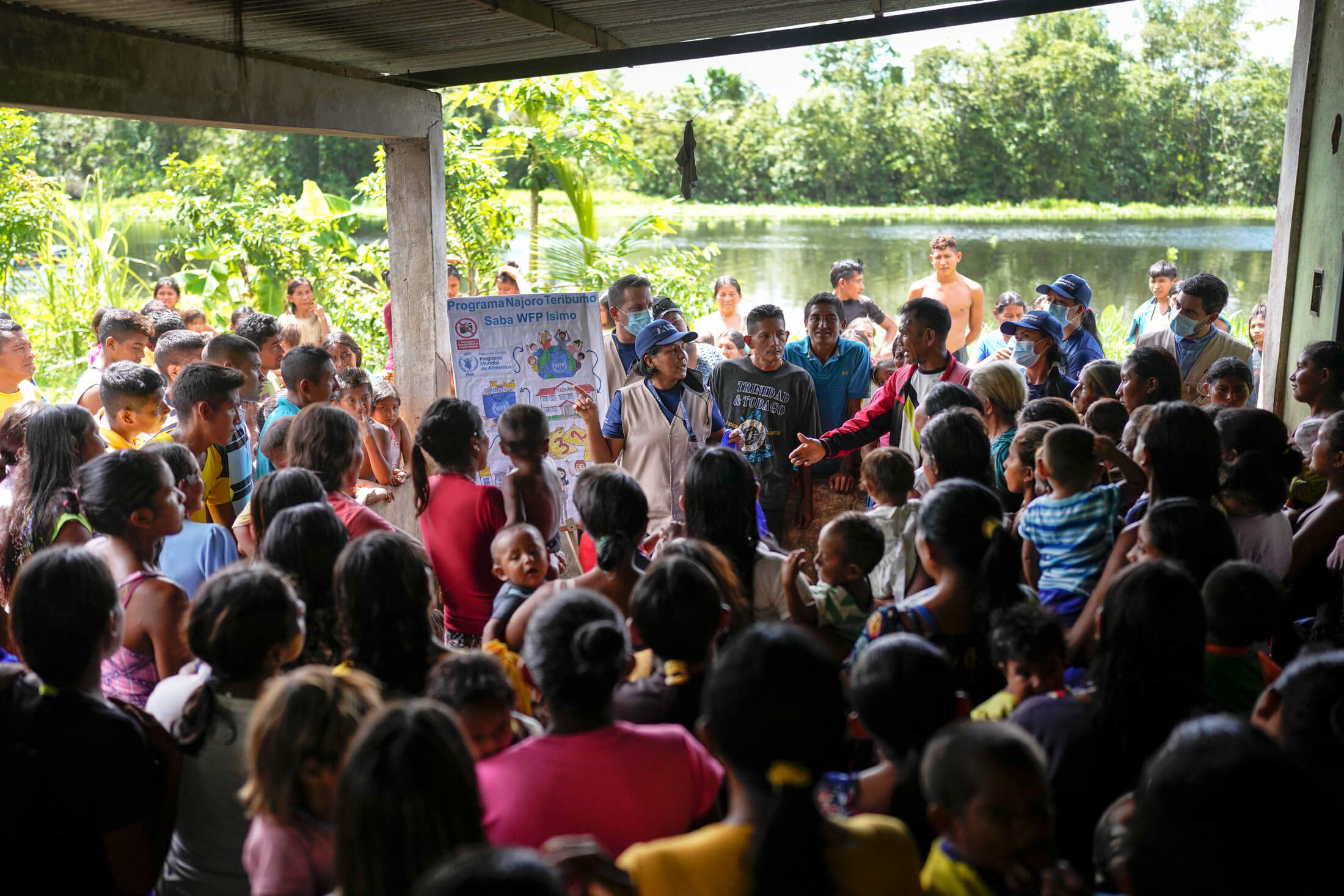 Dalia Mendoza, a Warao translator with International Medical Corps, talks to members of the indigenous Warao community about the school meal programme and its benefits. (Photo: Matias Delacroix, WFP) 