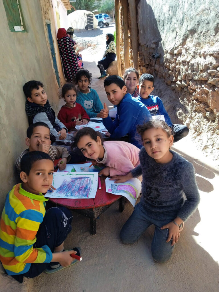 Children practice drawing at a child-friendly space in Morocco.