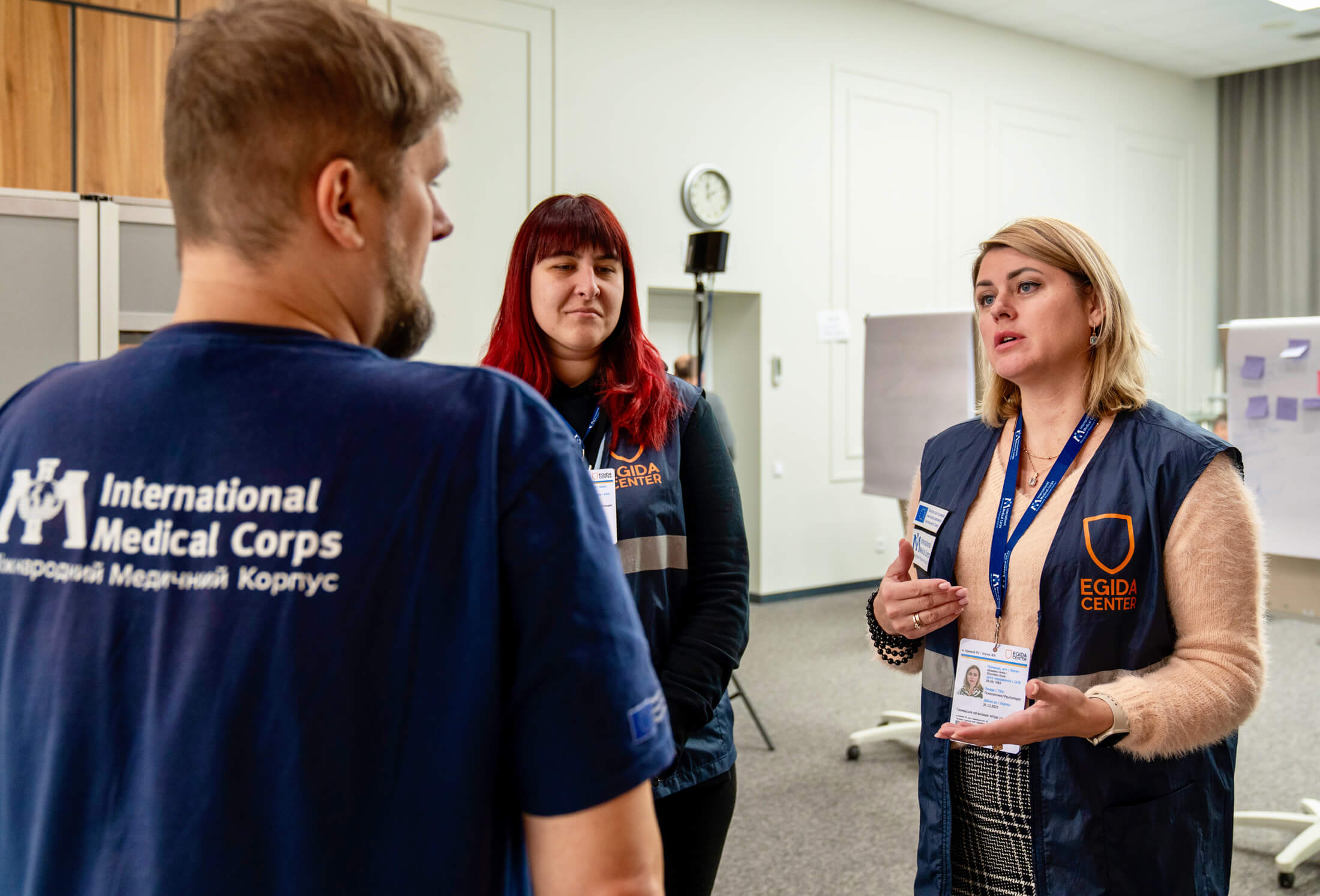 Egida Center psychologists Anna Fesenko, left, and Anna Shumeiko, right, speak with an International Medical Corps staff member during a recent MHPSS training session.