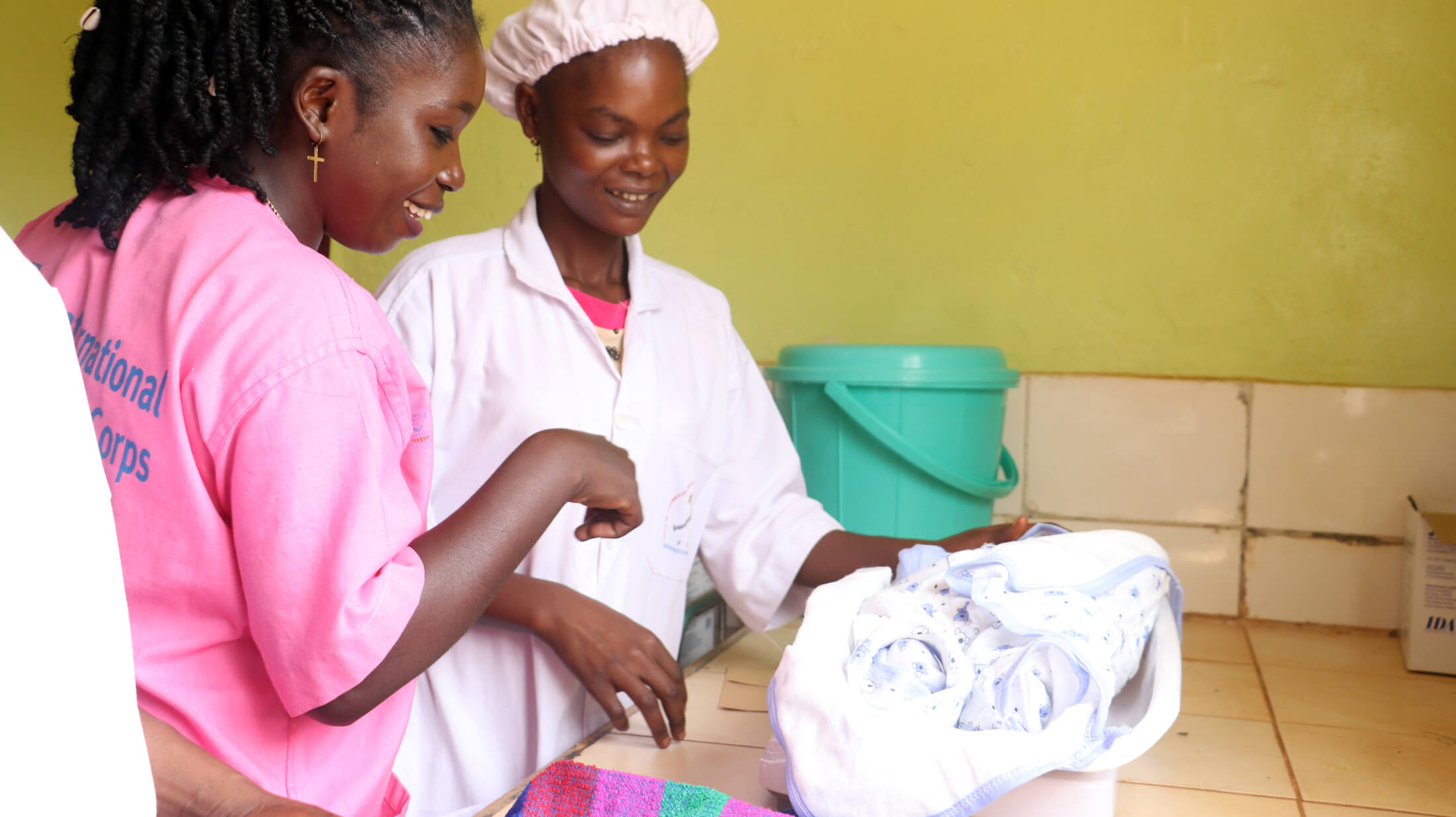 An International Medical Corps midwife supervises a Bria school student as she weighs a newborn at the Regional University Hospital of Bria.