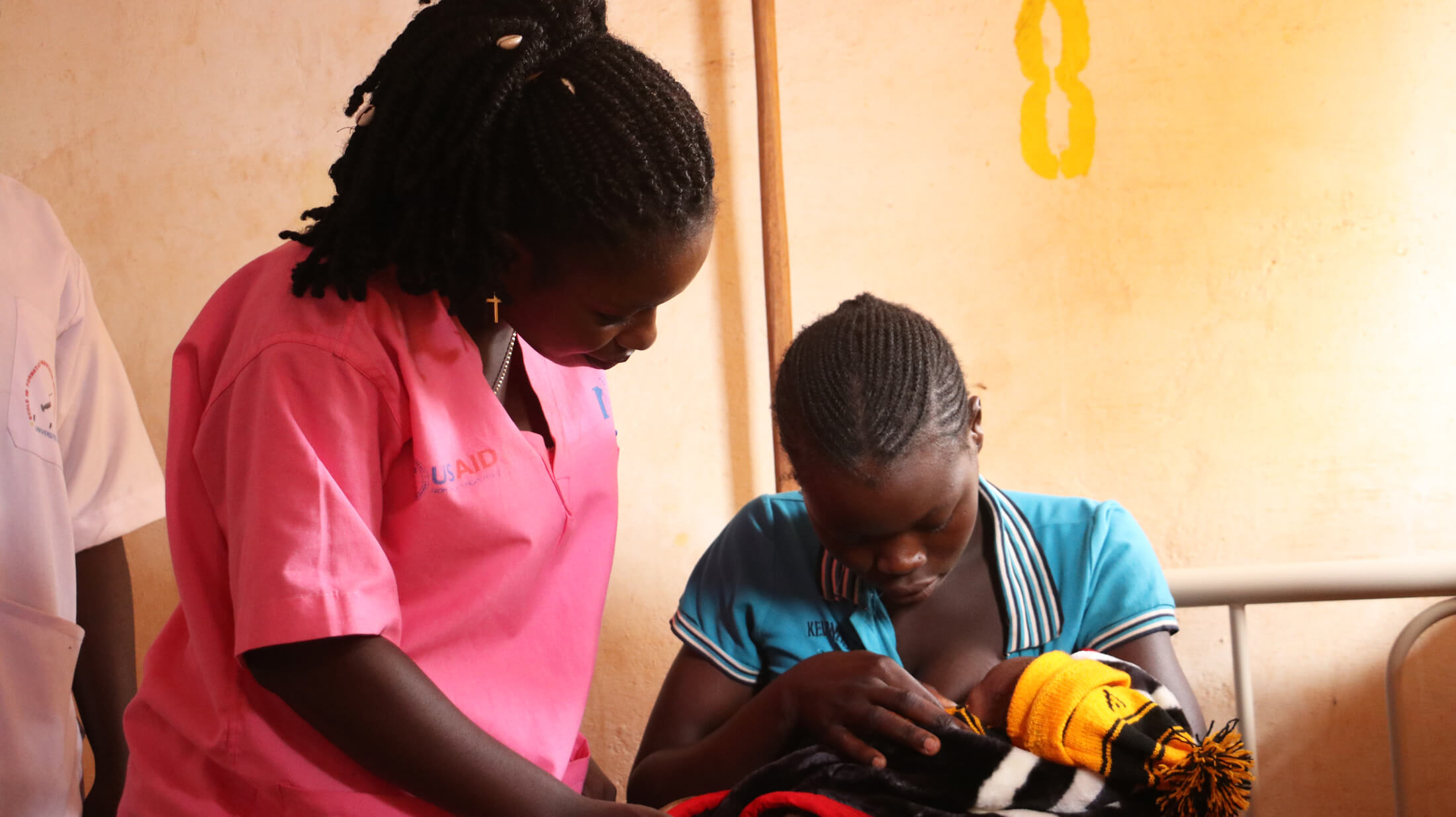 An International Medical Corps midwife assists a new mother at the Regional University Hospital of Bria as she practices breastfeeding.