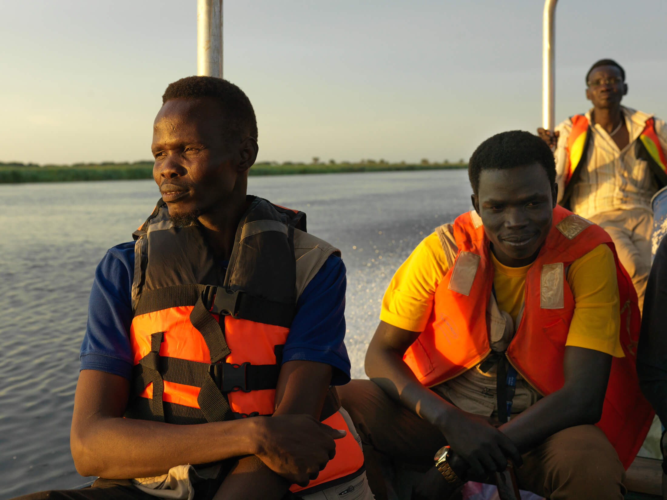 International Medical Corps staff members help flood-affected residents in Lul village. Stephen Odok, Accountable and Inclusive Programming Assistant, is in the blue shirt, while Ajaken Okey Lual, Community-based Feedback and Response Mechanism Clerk, is in the yellow shirt.