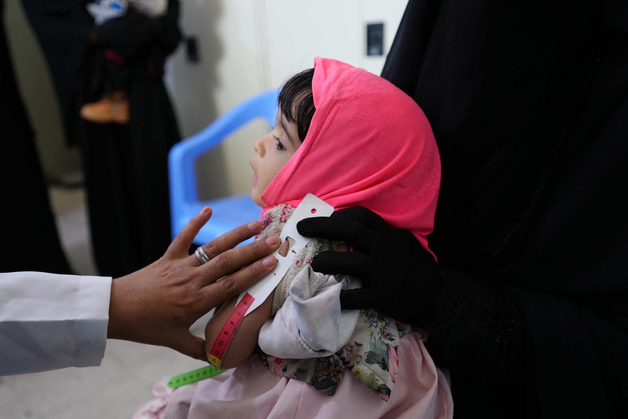 At a health facility in Al Dhale’e governorate, a nutrition worker assesses a young girl’s nutritional status by measuring her mid-upper arm circumference.