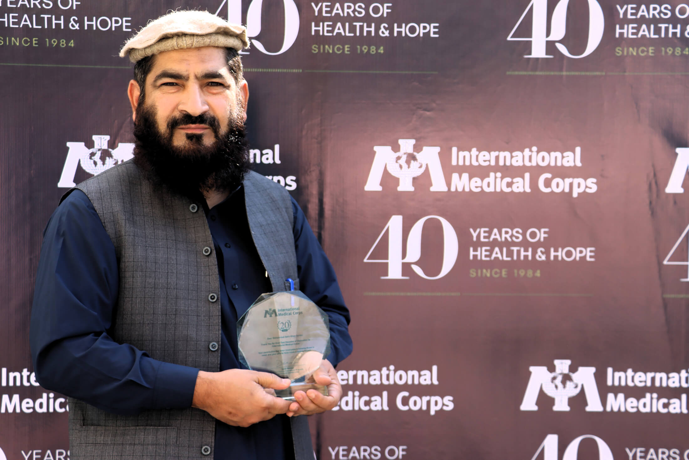 Dr. Mohammad Zahir, Field Director, holds an award he received after working for International Medical Corps for more than 20 years.